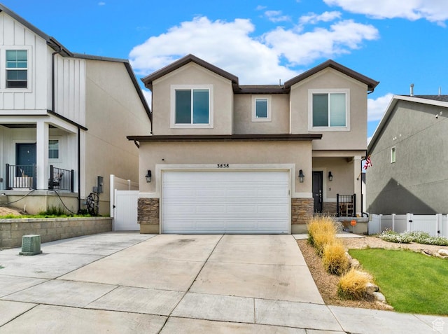 3838 S Mcelroy Rd W, Magna, UT 84044 - view of front of house featuring an attached garage, stone siding, stucco siding, and driveway