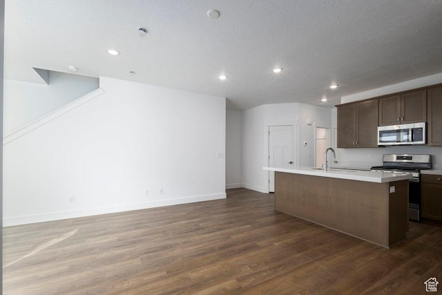 1753 W 160 S Unit 45, Pleasant Grove, UT 84062 - kitchen featuring an island with sink, dark wood-style flooring, a sink, light countertops, and appliances with stainless steel finishes