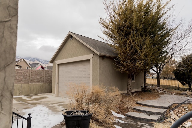 garage with fence and driveway
