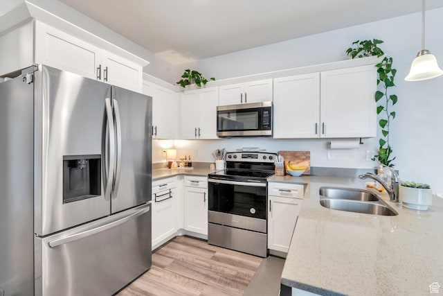 972 W Spider Green Way W Unit E201, Saratoga Springs, UT 84045 - kitchen featuring pendant lighting, light wood finished floors, appliances with stainless steel finishes, white cabinets, and a sink