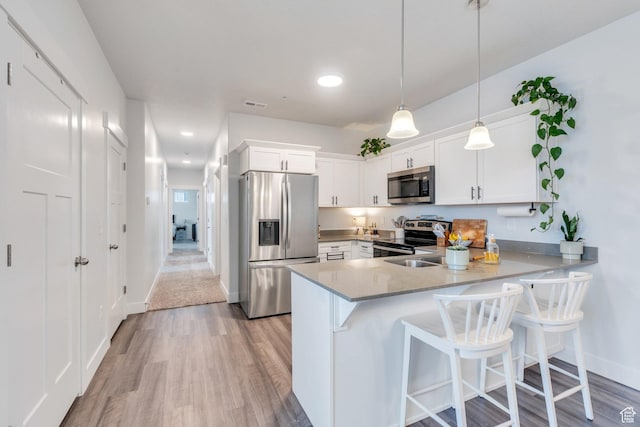 972 W Spider Green Way W Unit E201, Saratoga Springs, UT 84045 - kitchen featuring a peninsula, appliances with stainless steel finishes, white cabinets, and decorative light fixtures