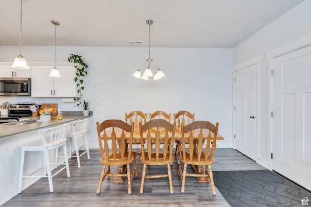 972 W Spider Green Way W Unit E201, Saratoga Springs, UT 84045 - dining room featuring dark wood-type flooring, visible vents, a notable chandelier, and baseboards