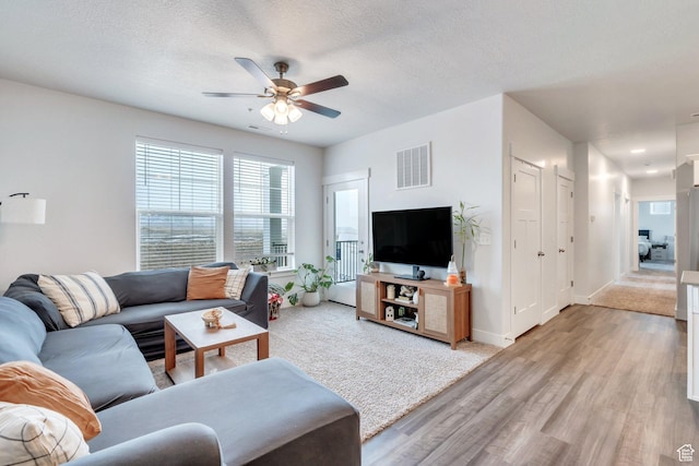 972 W Spider Green Way W Unit E201, Saratoga Springs, UT 84045 - living area with light wood finished floors, visible vents, a ceiling fan, a textured ceiling, and baseboards