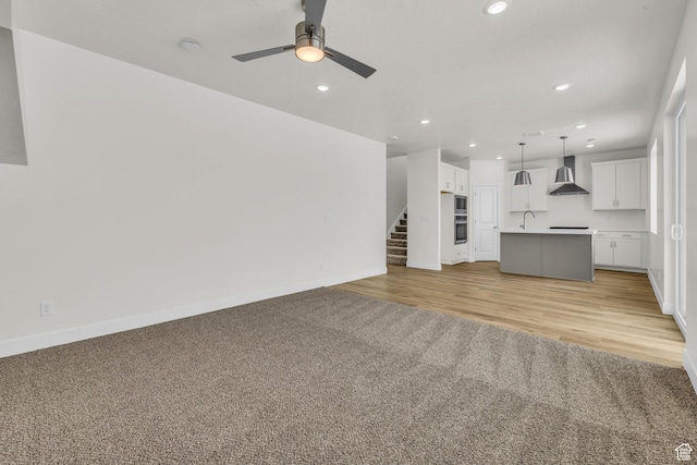 7181 Woods Rose Dr, Park City, UT 84098 - unfurnished living room featuring light carpet, recessed lighting, a ceiling fan, baseboards, and stairs