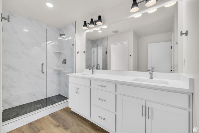 7181 Woods Rose Dr, Park City, UT 84098 - bathroom featuring a marble finish shower, double vanity, wood finished floors, and recessed lighting