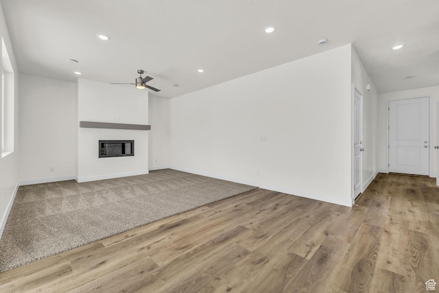 7181 Woods Rose Dr, Park City, UT 84098 - unfurnished living room featuring a ceiling fan, recessed lighting, a glass covered fireplace, wood finished floors, and baseboards