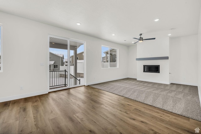7181 Woods Rose Dr, Park City, UT 84098 - unfurnished living room with a ceiling fan, wood finished floors, baseboards, a glass covered fireplace, and recessed lighting