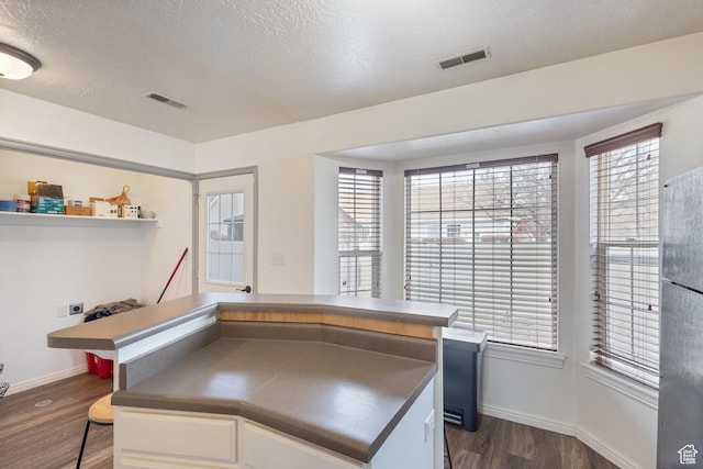 984 N Independence Ave W, Provo, UT 84604 - kitchen featuring visible vents, dark countertops, dark wood-type flooring, freestanding refrigerator, and a textured ceiling
