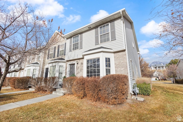view of property with a front lawn and brick siding
