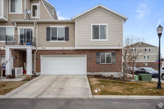 view of front of property featuring brick siding, concrete driveway, and a garage