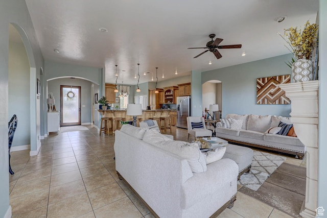 1163 W Sunrise Cir, Washington, UT 84780 - living room featuring light tile patterned floors, baseboards, arched walkways, a ceiling fan, and recessed lighting