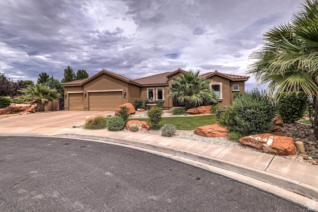 1163 W Sunrise Cir, Washington, UT 84780 - mediterranean / spanish-style home with a garage, driveway, a tile roof, and stucco siding