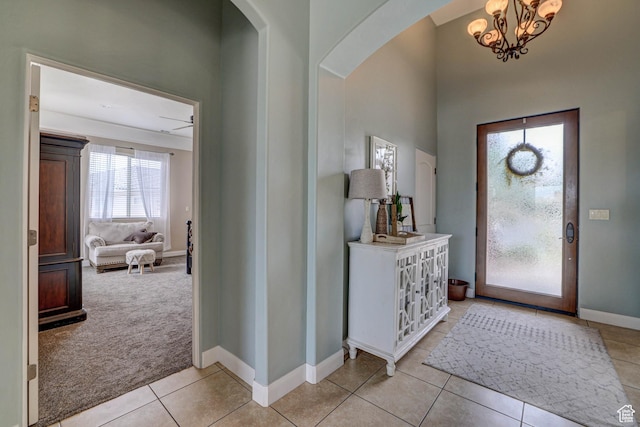 1163 W Sunrise Cir, Washington, UT 84780 - foyer with light tile patterned floors, baseboards, arched walkways, light colored carpet, and a chandelier