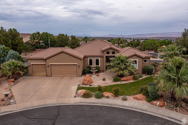 1163 W Sunrise Cir, Washington, UT 84780 - mediterranean / spanish home with an attached garage, a mountain view, a tiled roof, driveway, and stucco siding