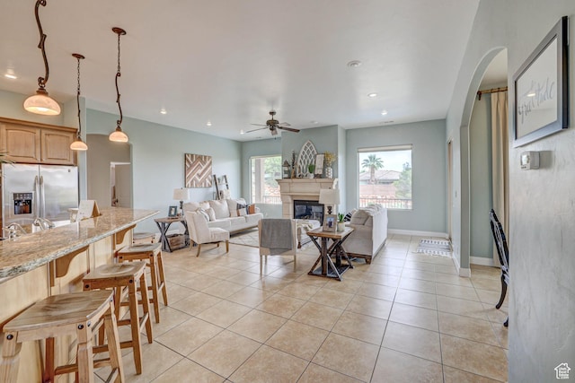 1163 W Sunrise Cir, Washington, UT 84780 - living area with light tile patterned floors, arched walkways, a wealth of natural light, and a glass covered fireplace