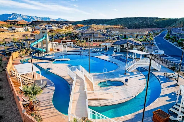 1466 N Arena Roja Dr, Washington, UT 84780 - view of swimming pool featuring a community hot tub, a water slide, a residential view, and a mountain view