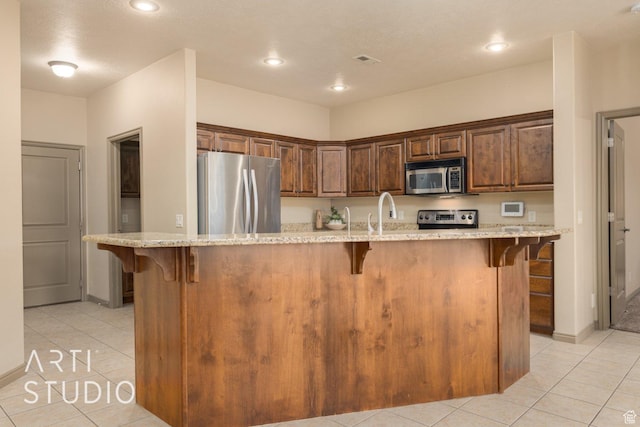 1109 N Ventana Dr, Washington, UT 84780 - kitchen featuring stainless steel appliances, a center island with sink, and a kitchen breakfast bar