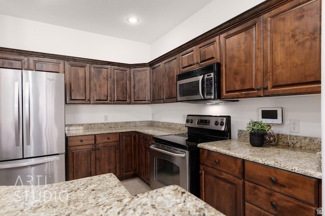 1109 N Ventana Dr, Washington, UT 84780 - kitchen with appliances with stainless steel finishes, light stone counters, dark brown cabinets, and light tile patterned floors