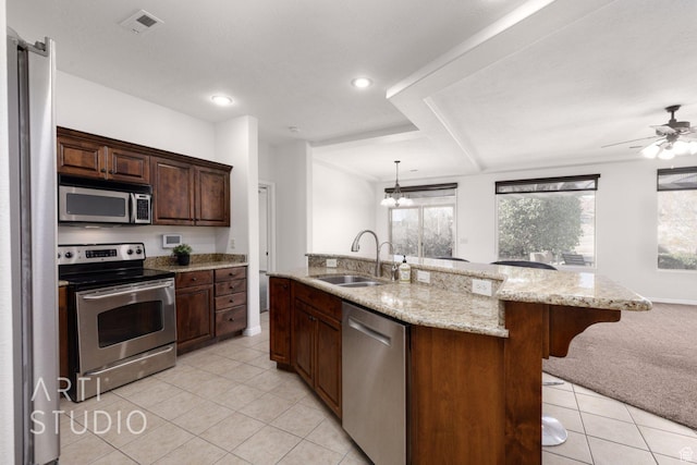 1109 N Ventana Dr, Washington, UT 84780 - kitchen with a center island with sink, hanging light fixtures, light stone countertops, stainless steel appliances, and a sink