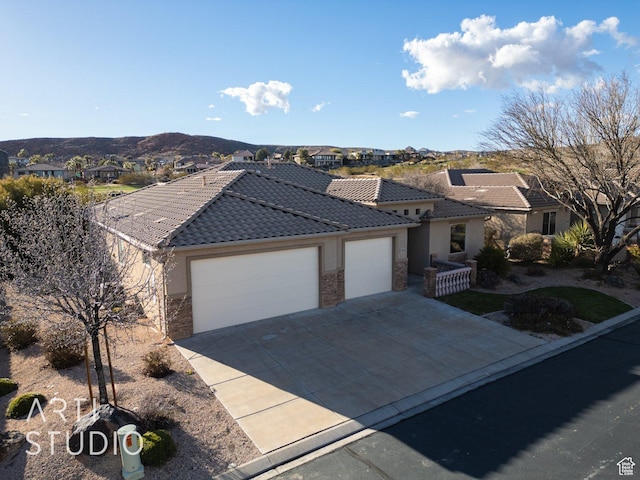 1109 N Ventana Dr, Washington, UT 84780 - ranch-style house featuring a garage, stone siding, a tile roof, and a mountain view