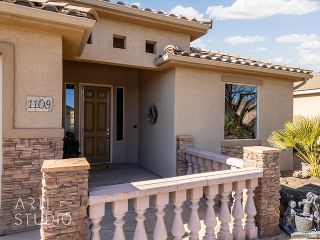 1109 N Ventana Dr, Washington, UT 84780 - view of exterior entry with stone siding, a tile roof, and stucco siding