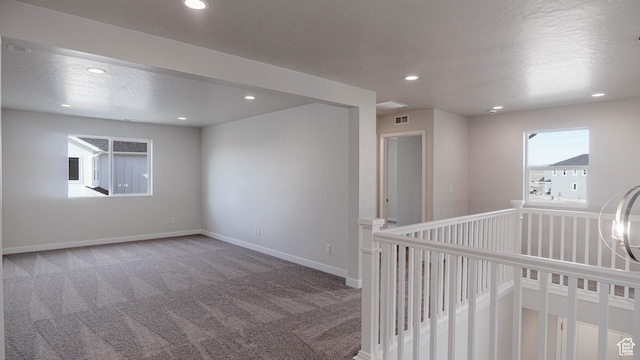 carpeted empty room featuring recessed lighting, visible vents, and baseboards