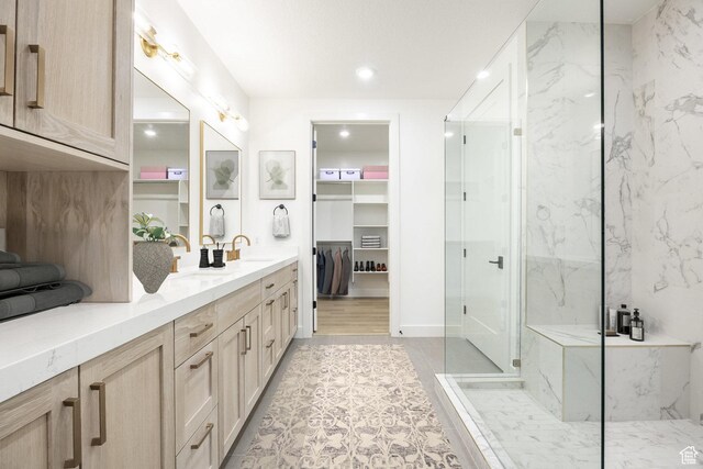 2250 E Murray Holladay Rd Unit 205, Holladay, UT 84117 - full bathroom with double vanity, a sink, a marble finish shower, and a walk in closet