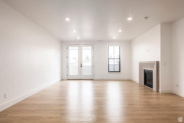 2250 E Murray Holladay Rd Unit 205, Holladay, UT 84117 - unfurnished living room with a glass covered fireplace, baseboards, light wood finished floors, and recessed lighting