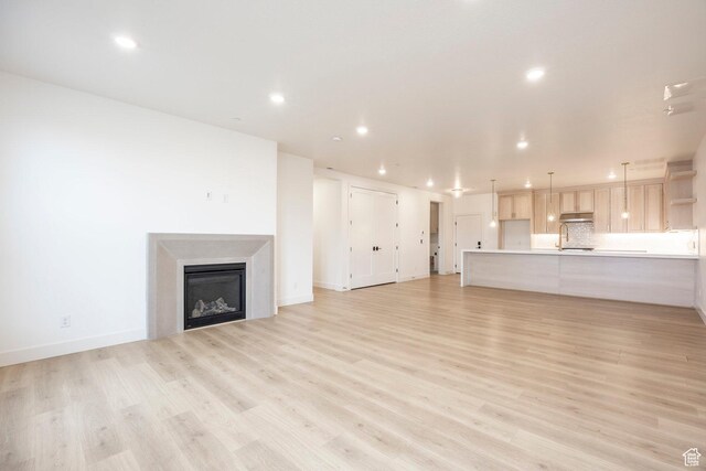 2250 E Murray Holladay Rd Unit 205, Holladay, UT 84117 - unfurnished living room with recessed lighting, a fireplace, a sink, baseboards, and light wood-type flooring