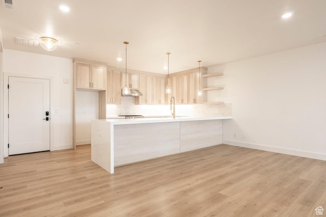 2250 E Murray Holladay Rd Unit 205, Holladay, UT 84117 - kitchen with tasteful backsplash, light countertops, a peninsula, and ventilation hood