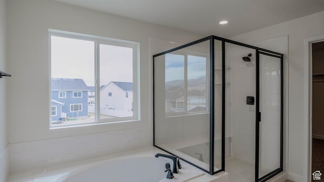 bathroom with a stall shower, a garden tub, recessed lighting, and a wealth of natural light