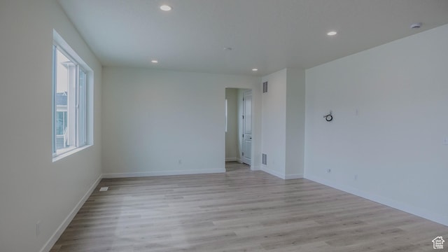 unfurnished room with recessed lighting, light wood finished floors, visible vents, and baseboards