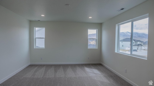 carpeted empty room with recessed lighting, plenty of natural light, visible vents, and baseboards