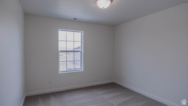 empty room featuring carpet floors, baseboards, and visible vents