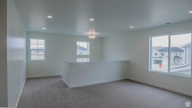 empty room featuring carpet floors, baseboards, and visible vents