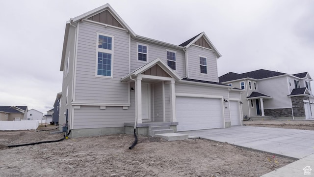 traditional home with board and batten siding, a garage, and concrete driveway