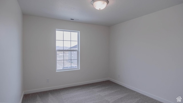 unfurnished room with visible vents, baseboards, and carpet flooring