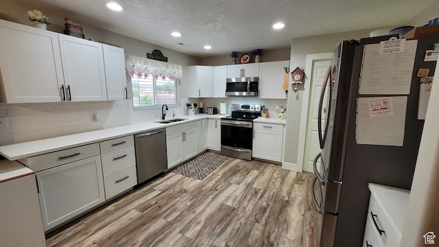 657 W 150 S, Hurricane, UT 84737 - kitchen featuring white cabinets, light wood-style flooring, appliances with stainless steel finishes, light countertops, and a sink