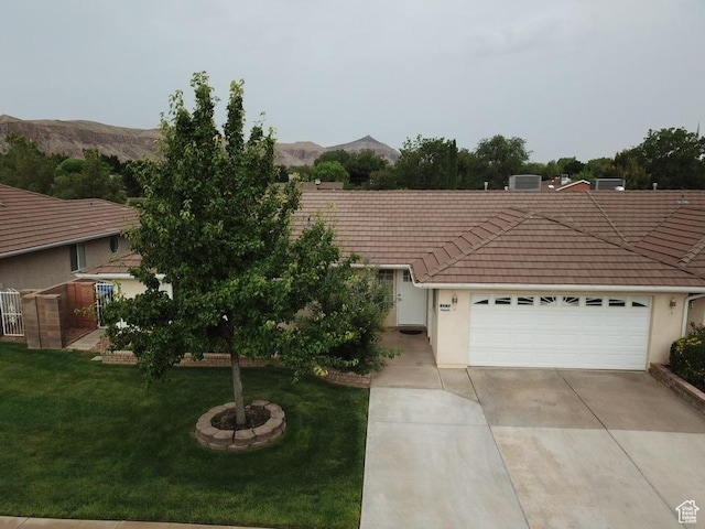 657 W 150 S, Hurricane, UT 84737 - view of front of property with concrete driveway, a front lawn, a tiled roof, and a mountain view