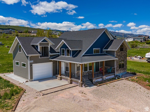 1595 S Bear Lake Blvd, Garden City, UT 84028 - view of front facade featuring a garage, covered porch, a mountain view, and concrete driveway