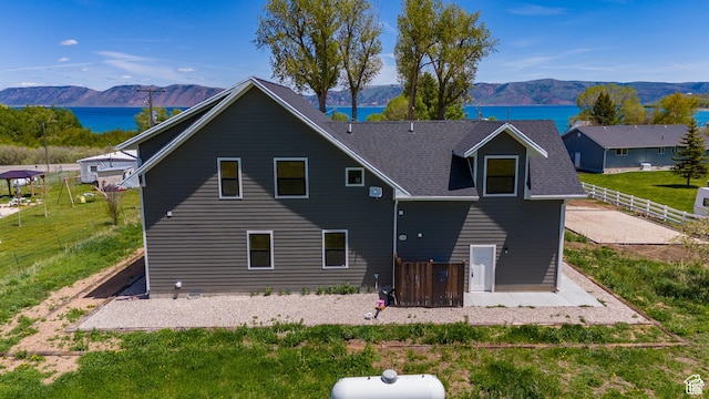 1595 S Bear Lake Blvd, Garden City, UT 84028 - back of house featuring fence, a water and mountain view, and roof with shingles