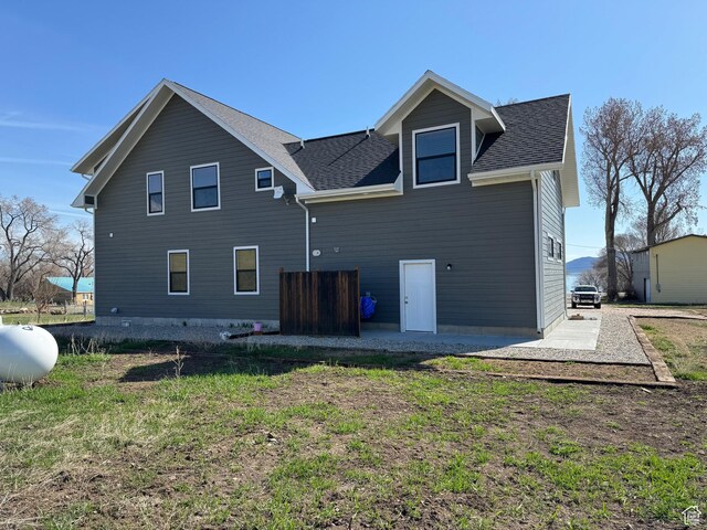 1595 S Bear Lake Blvd, Garden City, UT 84028 - back of property with a shingled roof, a lawn, and a patio
