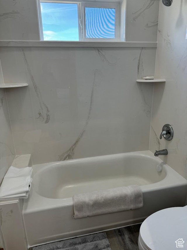 1595 S Bear Lake Blvd, Garden City, UT 84028 - full bath featuring toilet, wood finished floors, a wealth of natural light, and shower / bathing tub combination