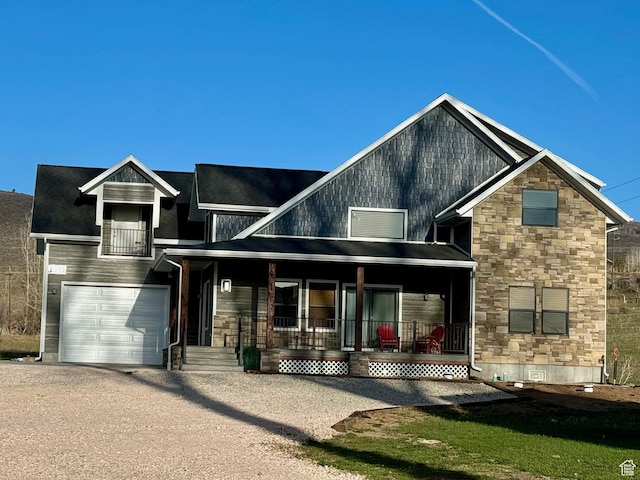 1595 S Bear Lake Blvd, Garden City, UT 84028 - view of front of home with driveway, a garage, stone siding, crawl space, and a porch