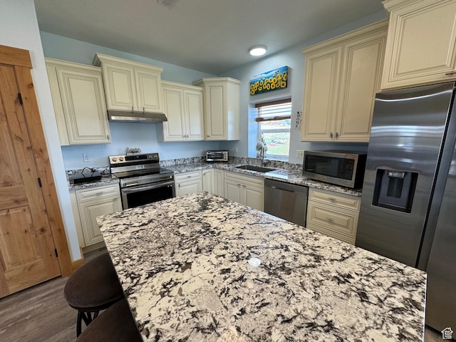 1595 S Bear Lake Blvd, Garden City, UT 84028 - kitchen featuring stainless steel appliances, cream cabinets, a sink, and under cabinet range hood