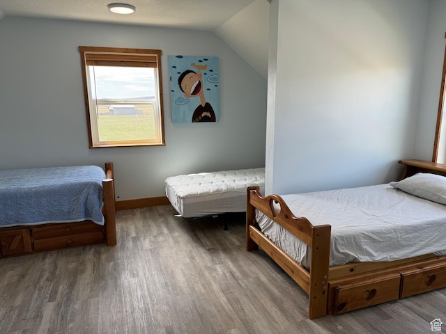 1595 S Bear Lake Blvd, Garden City, UT 84028 - bedroom with lofted ceiling, a textured ceiling, wood finished floors, and baseboards