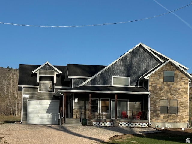 1595 S Bear Lake Blvd, Garden City, UT 84028 - view of front facade featuring dirt driveway, stone siding, an attached garage, crawl space, and a porch