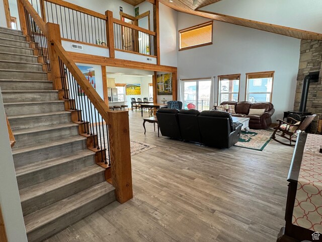 1595 S Bear Lake Blvd, Garden City, UT 84028 - living area featuring visible vents, stairway, a wood stove, wood finished floors, and high vaulted ceiling