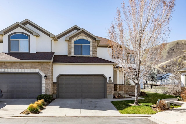 view of property with concrete driveway, stucco siding, stone siding, and a garage