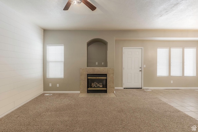 898 E Tendoy Ct S, Draper, UT 84020 - unfurnished living room featuring ceiling fan, carpet, a textured ceiling, a tiled fireplace, and tile patterned floors